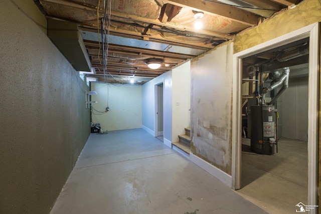 unfinished below grade area featuring water heater and stairs