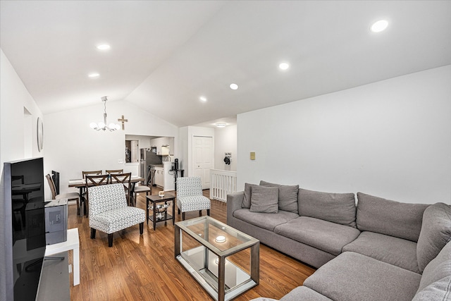 living area with a notable chandelier, recessed lighting, lofted ceiling, and wood finished floors