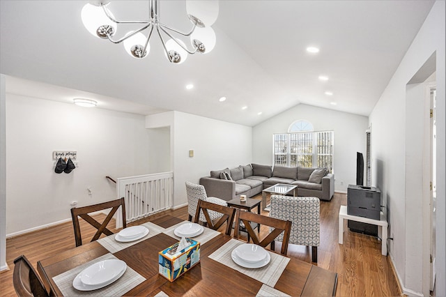 dining space with a chandelier, baseboards, wood finished floors, and vaulted ceiling