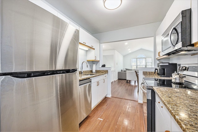 kitchen featuring a sink, appliances with stainless steel finishes, white cabinets, light wood finished floors, and light stone countertops