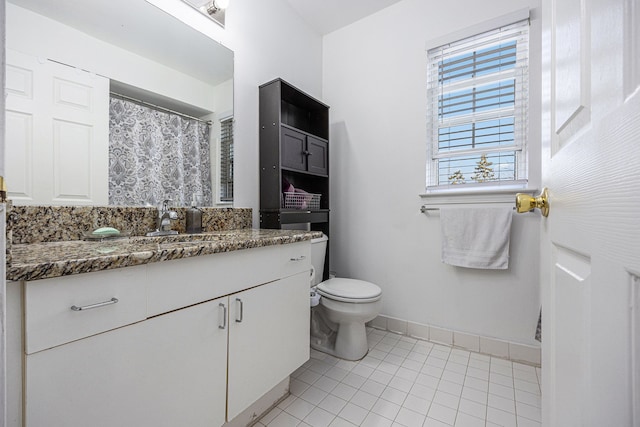 bathroom featuring tile patterned flooring, toilet, vanity, and baseboards