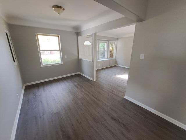 unfurnished room featuring dark wood-style floors and baseboards