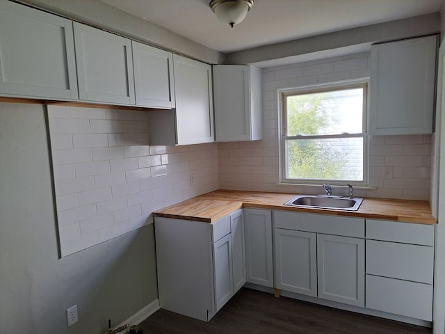 kitchen featuring decorative backsplash, wood counters, and a sink