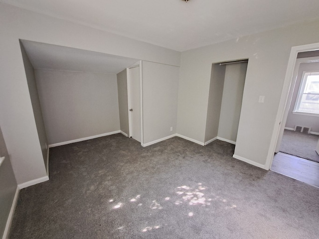 unfurnished bedroom featuring visible vents, carpet, baseboards, and a closet