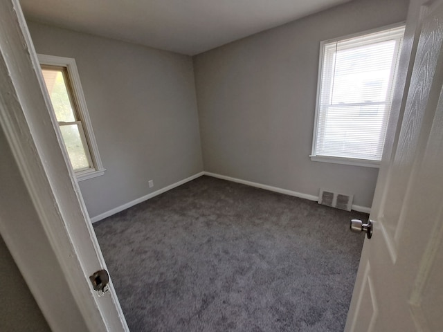 spare room with visible vents, baseboards, and carpet flooring