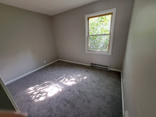 carpeted spare room with baseboards and visible vents