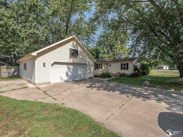 view of front of property with a garage, driveway, a front lawn, and fence