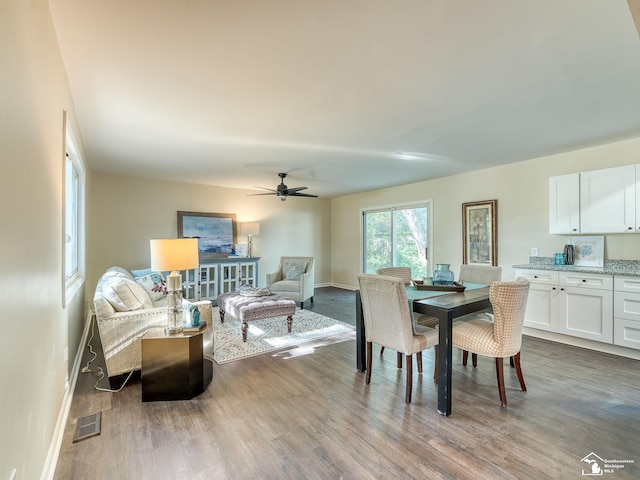 dining room with ceiling fan, visible vents, baseboards, and wood finished floors