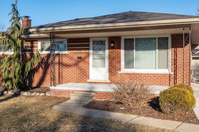 view of front of house featuring brick siding and a shingled roof