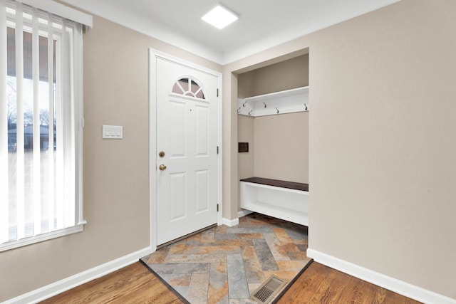 mudroom with visible vents, baseboards, and stone finish floor