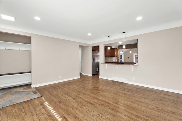 unfurnished living room featuring recessed lighting, visible vents, baseboards, and wood finished floors