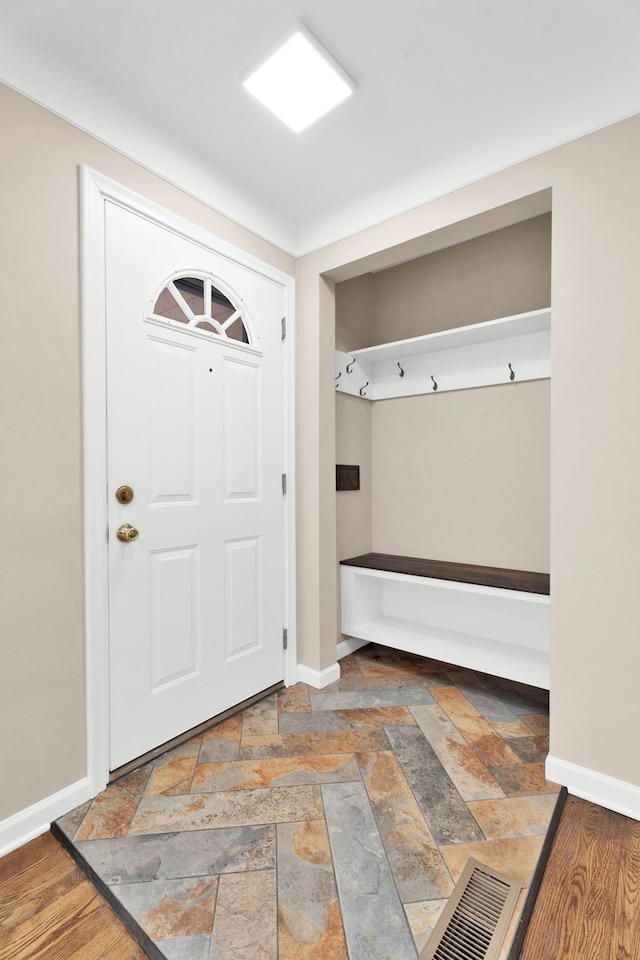 mudroom featuring stone tile floors, visible vents, and baseboards