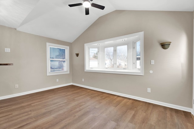 spare room with baseboards, a ceiling fan, lofted ceiling, and wood finished floors