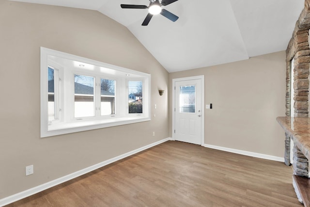 entryway featuring plenty of natural light, baseboards, lofted ceiling, and wood finished floors