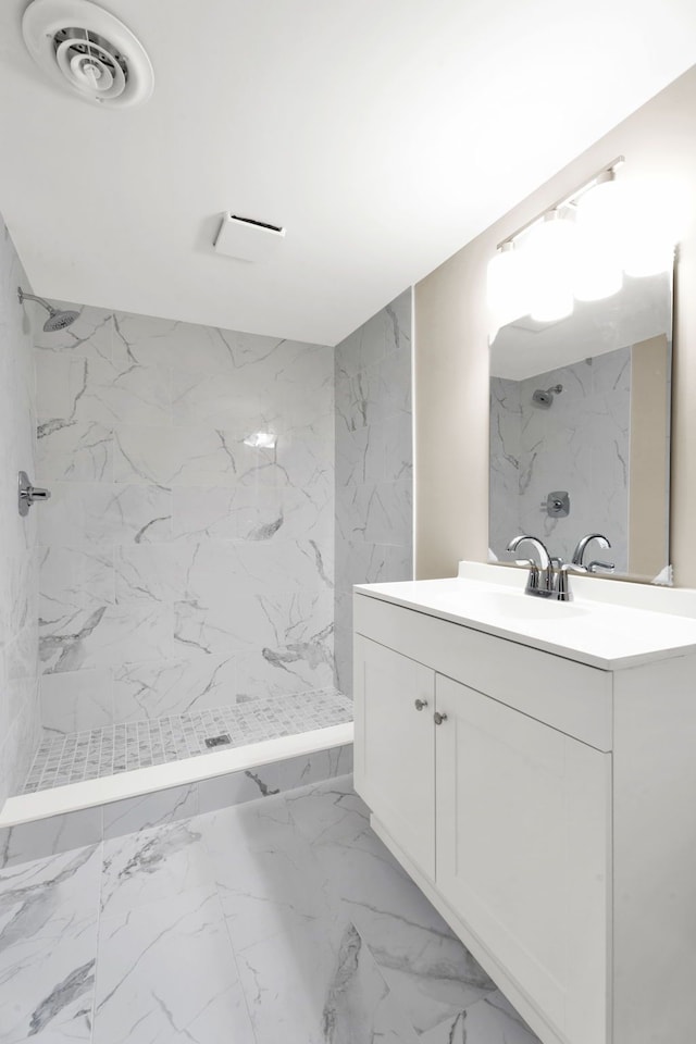 bathroom featuring vanity, marble finish floor, visible vents, and a marble finish shower