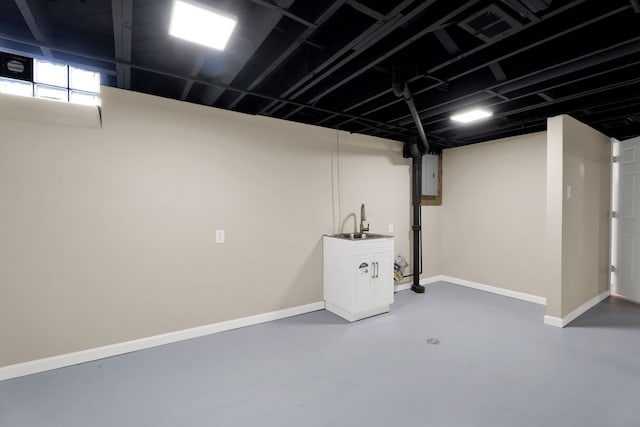 basement with electric panel, visible vents, baseboards, and a sink