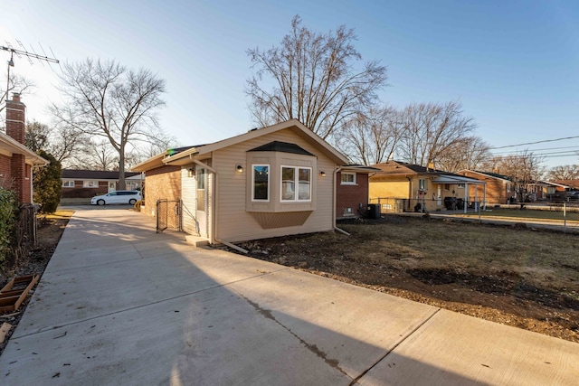 exterior space with concrete driveway, brick siding, and a residential view