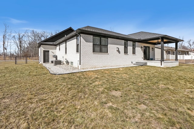 back of property with a patio area, a lawn, and brick siding