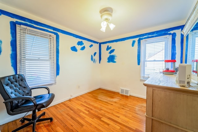 interior space featuring light wood-type flooring, visible vents, and baseboards