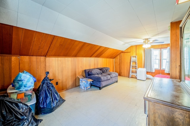 bonus room with lofted ceiling, light floors, and wood walls