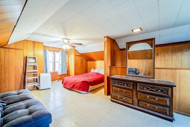 bedroom with lofted ceiling, a ceiling fan, light floors, and wood walls