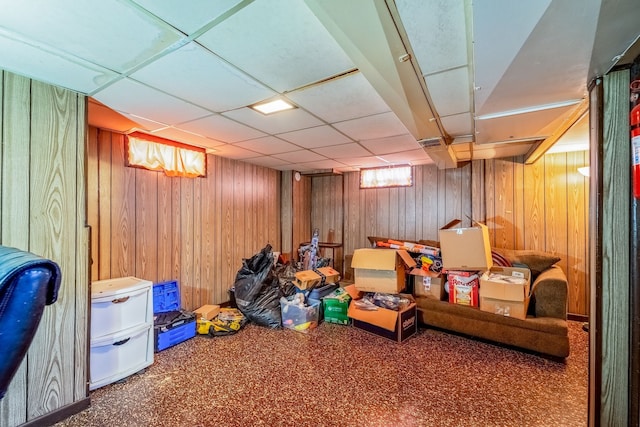 below grade area with wooden walls and a drop ceiling