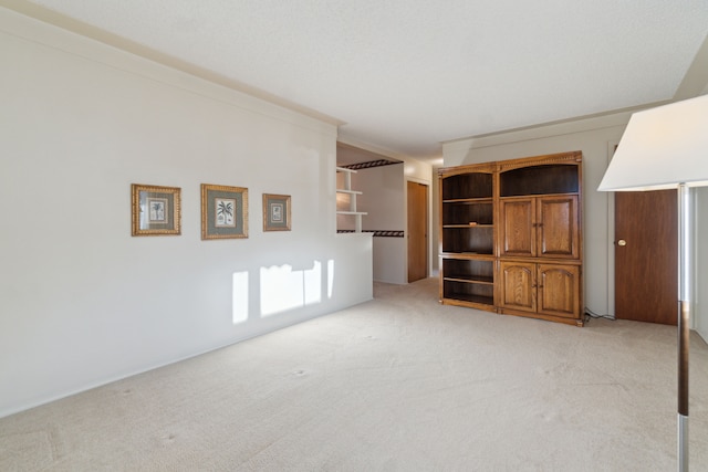 unfurnished living room with light carpet and crown molding