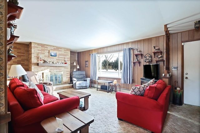 carpeted living area featuring wood walls, baseboard heating, and a fireplace