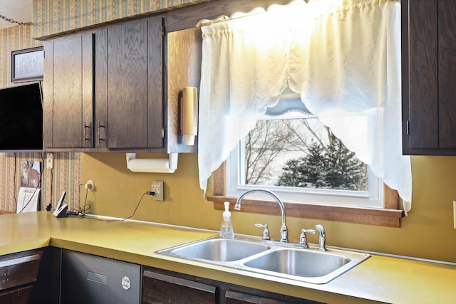 kitchen with light countertops, dark brown cabinetry, a sink, and dishwasher