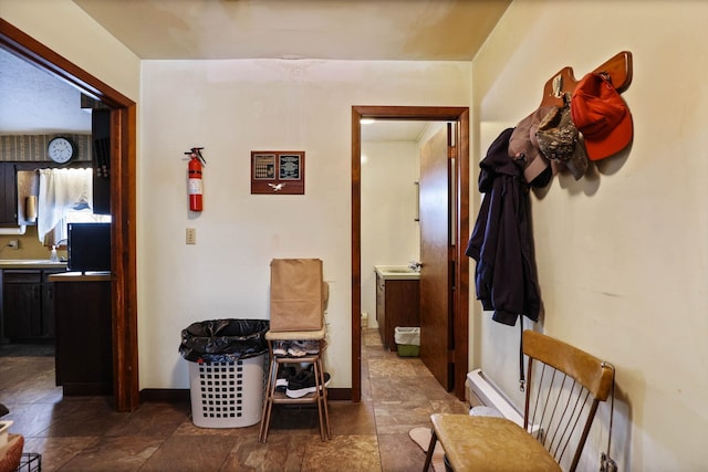 hall with baseboards and stone finish flooring