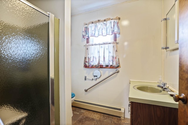 full bathroom with stone finish flooring, a shower stall, vanity, a baseboard radiator, and toilet