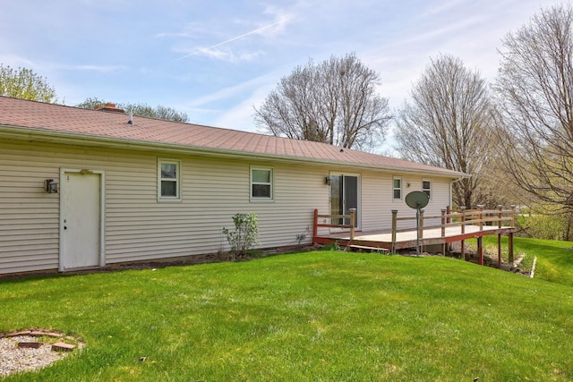 rear view of property with a yard and a deck