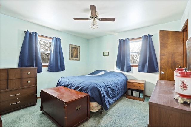 bedroom with carpet, ceiling fan, and multiple windows