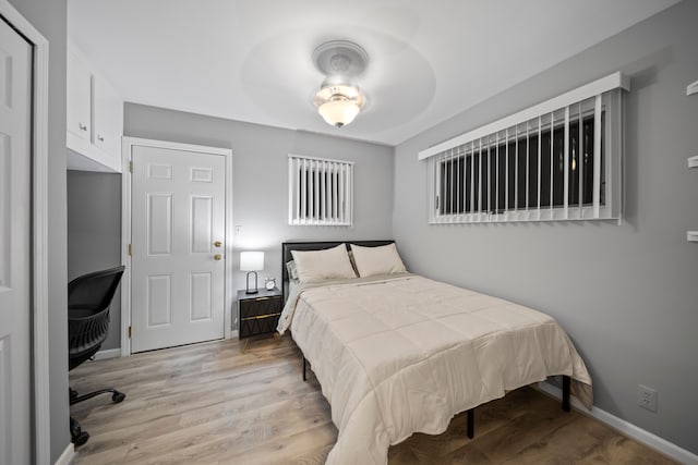 bedroom with baseboards and light wood finished floors