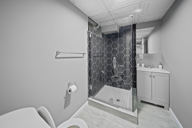 bathroom featuring a shower stall, toilet, vanity, and baseboards