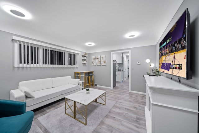 living room featuring baseboards and light wood-style flooring