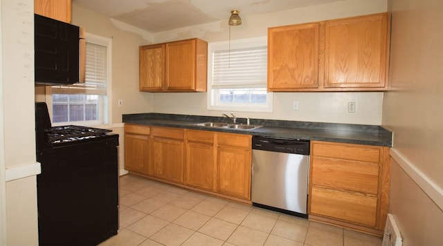 kitchen featuring visible vents, black appliances, a sink, dark countertops, and brown cabinetry