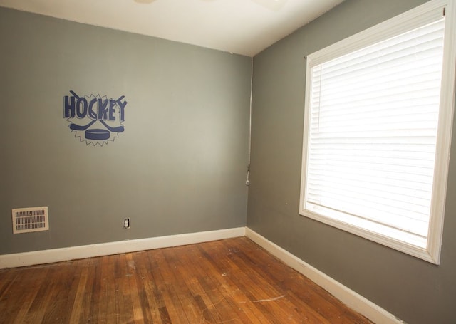 unfurnished room featuring hardwood / wood-style floors, plenty of natural light, baseboards, and visible vents