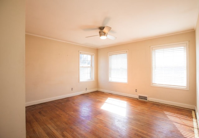 spare room featuring visible vents, wood finished floors, baseboards, and ornamental molding