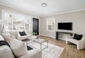 living area featuring a wealth of natural light, baseboards, wood finished floors, and crown molding