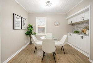 dining area featuring baseboards, wood finished floors, and crown molding