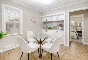 dining space featuring visible vents, baseboards, light wood-style floors, and ornamental molding