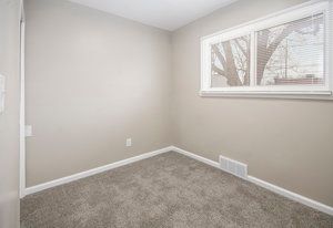 carpeted empty room featuring visible vents and baseboards