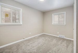 unfurnished room with visible vents, carpet, and baseboards