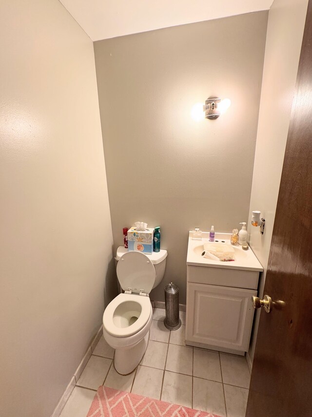 bathroom featuring baseboards, toilet, tile patterned floors, and vanity