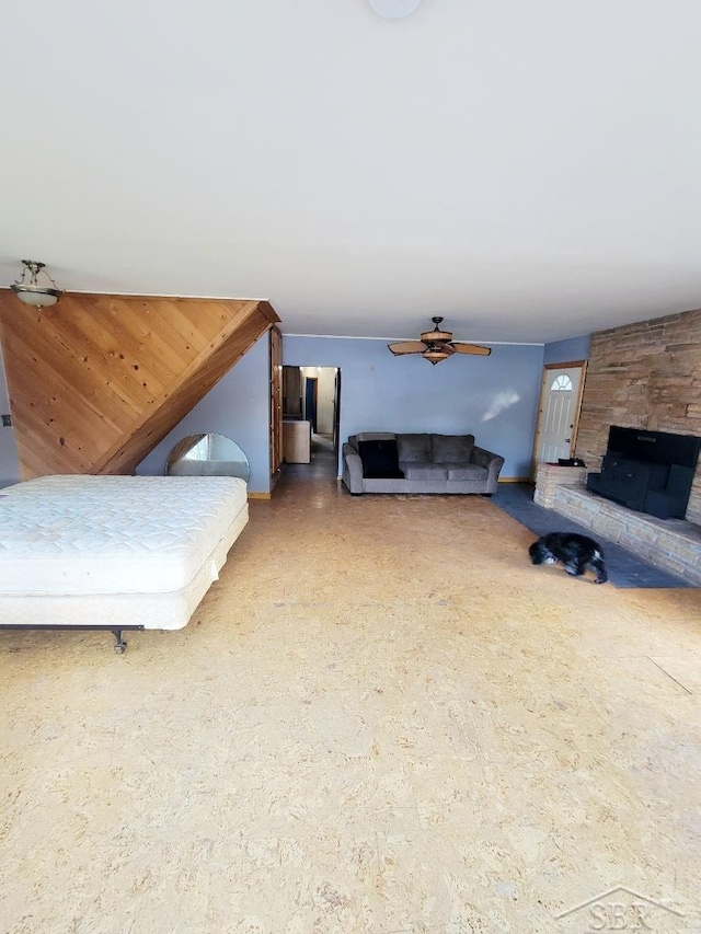 bedroom featuring wooden walls and a fireplace