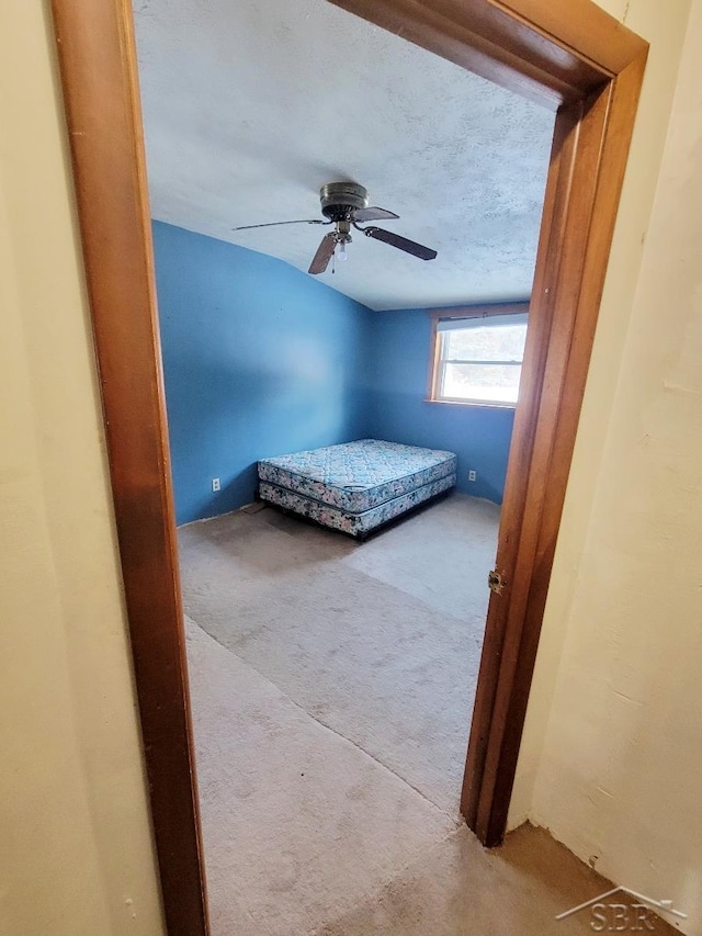 carpeted bedroom with a ceiling fan and a textured ceiling