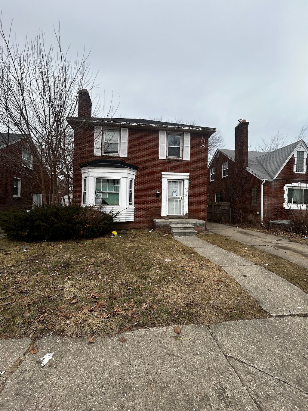 view of front facade with brick siding and a chimney