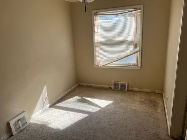 carpeted empty room with visible vents and baseboards