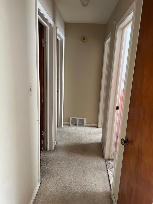 corridor with visible vents, baseboards, and carpet flooring